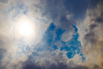 View of the calm cloudy sky through the clouds the rays break through on summer day.