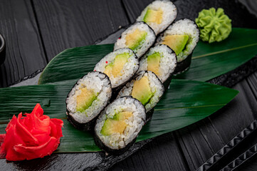 Appetizing sushi maki roll on a black stone plate