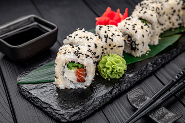 Traditional Japanese cuisine maki sushi rolls with salmon, avocado, cream cheese and sesame.