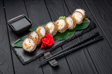 Hot tempura roll with salmon and cheese, Traditional delicious fresh sushi roll set on a black background.