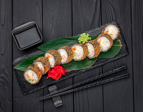 Hot tempura roll with salmon and cheese, Traditional delicious fresh sushi roll set on a black background.