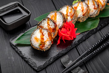 Hot tempura roll with salmon and cheese, Traditional delicious fresh sushi roll set on a black background.