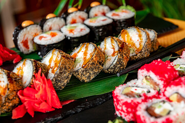 Big set of Asian food. Sushi and rolls on a dark background.