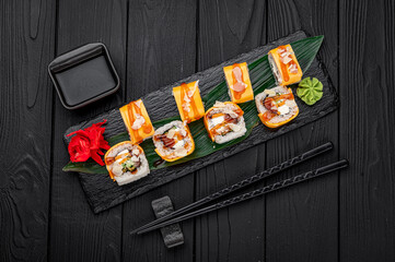 Traditional delicious fresh sushi roll set on a black background . Sushi roll with rice, cream cheese, salmon.