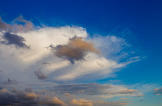 cloud against a thunderstorm sky at sunset, illuminated by the sun's rays