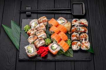 Big set of Asian food. Sushi and rolls on a dark background.