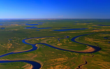 Northern lowland tundra with swamps, lakes and river meanders in spring. - obrazy, fototapety, plakaty