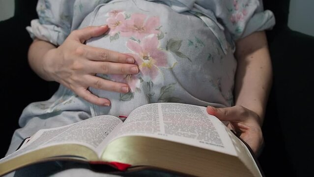 Pregnant caucasian woman reading the holy bible