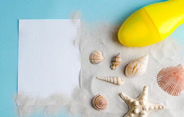 Seashells, sand, sunscreen and blank paper on a blue background with space for text.