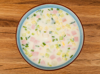A plate of okroshka on a wooden background.