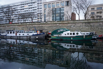 Obraz premium mirror reflection of the moored boats and buildings in the river Seine in downtown Paris, France