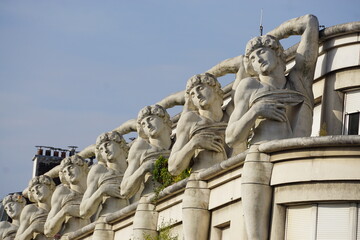 Obraz premium several statues of the same man decorating the top of a building in downtown Paris, France