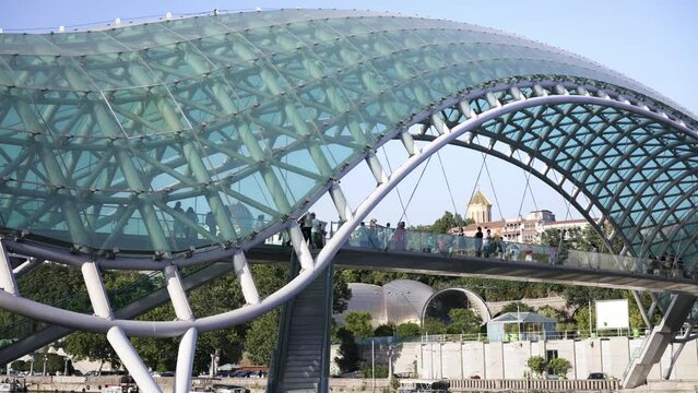 Bridge of Peace, pedestrian bridge over Kura River in Tbilisi, capital of Georgia. Built with steel, blue glass, modern design. 