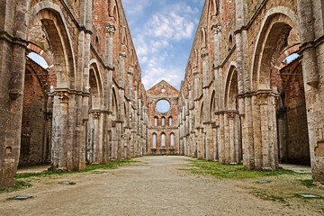 Naklejka premium San Galgano abbey in Chiusdino, Siena, Tuscany, Italy. Roofless nave with colonnade of the medieval Gothic style church. It has been a location for films by Tarkovsky, Vadim and others