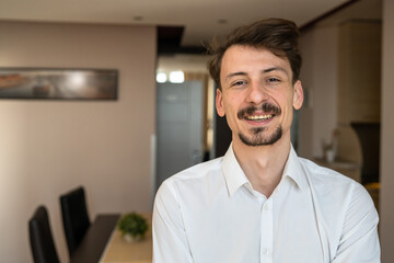 Obraz premium Portrait of young adult caucasian man in apartment wear white shirt