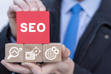 Businessman holding colorful blocks presents conceptual banner: SEO. Concept of Search Engine...