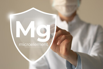 Microelement supplement concept. Shield in doctor`s hands with Magnesium icon.