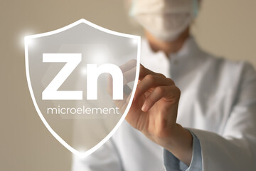 Microelement supplement concept. Shield in doctor`s hands with Zinc icon.