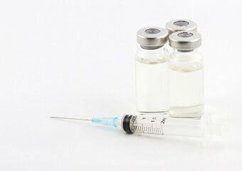 Healthcare and medical concept. Syringe and medical glass ampoules on white background