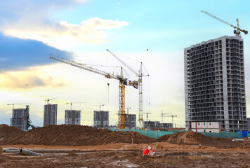 Construction site with building construction on sunset. Tower cranes in action. Housing renovation...