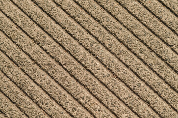 Close-up of a sidewalk lined with lines with an abstract surface. Pavement background texture with geometric pattern