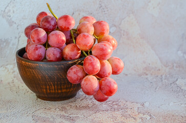 Bunch of grapes. Ripe large grape berries in a ceramic bowl on an abstract background. Vine.