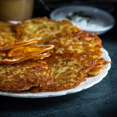 Potato pancakes or latke served with sour cream, dill, and applesauce. Garnished with dried orange slices.
.