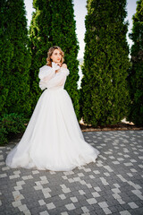 Fototapeta na wymiar beautiful bride posing in a white delicate dress in the park.