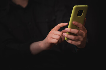 man interacting with his mobile phone, black background, communications theme