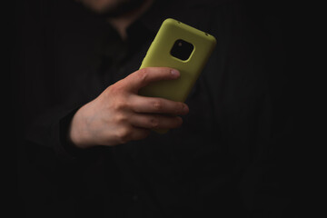 man using his smart phone to view applications, black background