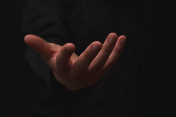 open hand with gesture of receiving, on black background, usable for opportunity, giving and...