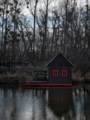 Wooden houseboat with red windows on the Little Dunaj river in the village of Zalesie, Slovakia