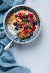 bowl wih a greek yogurt with raspberries and blueberries and mulberries