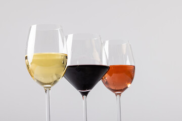 Glasses with red, rose and white wine on white background, with copy space