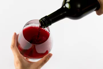 Keuken foto achterwand Hands holding bottle of red wine and glass on white background, with copy space © vectorfusionart