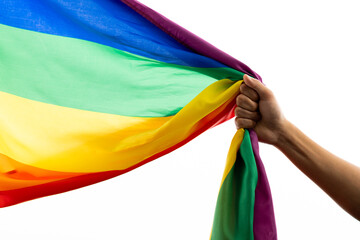 Hand holding rainbow coloured flag with copy space on white background