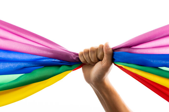 Hand holding rainbow coloured flag with copy space on white background