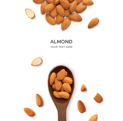 Creative layout made of almonds and wood spoon on a white background. Top view.  