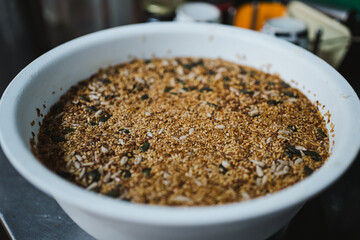 Bowl full of seeds hydrating with water for use in the preparation of seeded bread in a bakery