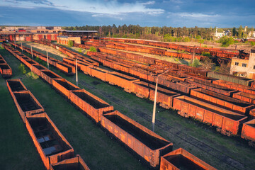 Drone view of freight trains at sunset. Old Railway cargo wagons with on railroad. Aerial view of...