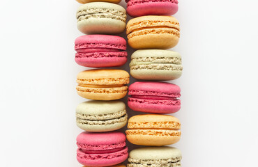 Pink, yellow and green macaroons close-up on a white background. Selective focus, space for text.