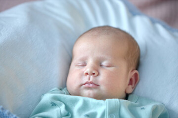 the newborn boy is sleeping. cute beautiful baby is sleeping closeup portrait of a beautiful sleeping baby on white.