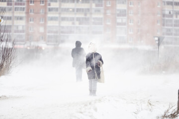 silhouette of a man walking in a snowstorm in the city the concept of a storm blizzard and bad weather.