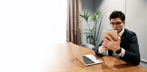 The work of a young entrepreneur a man in a startup is a space for work. Office work, manager using the Internet and online business. Copy space