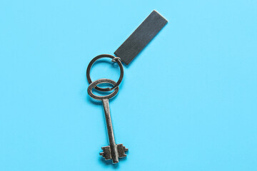 Key with metallic keychain on color background