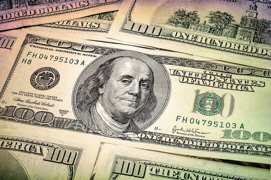 One hundred dollars. Portrait of President Benjamin Franklin. US dollars background. Closeup of a lot of banknotes hundred dollar bills.  Toned image