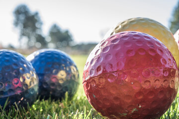Close up of a red, blue and gold golf balls used as tee box markers.