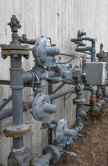 A vertical image of natural gas piping outside an apartment building downtown.