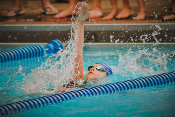 Girl swimming backstroke in pool - obrazy, fototapety, plakaty