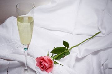 Valentines day background of objects with champagne and roses on a white table
